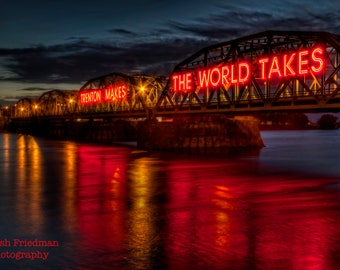 May include: A bridge over a river at night with red neon signs that read "Trenton Makes The World Takes".