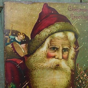 Peut inclure: Une carte de v&oelig;ux de No&euml;l vintage repr&eacute;sentant un portrait du P&egrave;re No&euml;l avec une longue barbe blanche et un chapeau rouge. La carte a un fond vert avec un effet neigeux et le texte "Christmas Greetings".