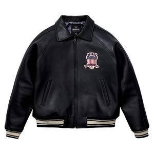 May include: A black leather jacket with a classic collar, a full-length front zipper, and ribbed cuffs and hem featuring white stripes. On the left chest, there is a patch displaying the text AVIREX above a shield with a red, white, and blue flag design.