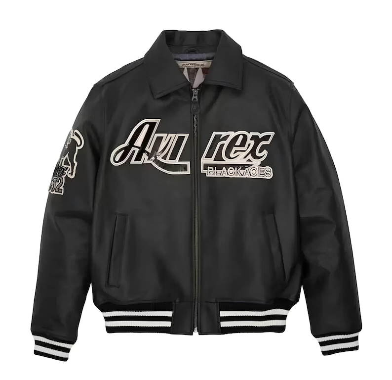 May include: A black leather bomber jacket featuring a front zipper closure, a collar, and striped ribbed cuffs and hem. The chest displays white and black embroidered text reading Avirex Black Aces, with a graphic patch on the right sleeve.