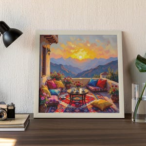 May include: A framed painting depicts a vibrant outdoor scene. A terrace with colorful cushions, a patterned rug, and a small table is set against a backdrop of mountains and a sunset. Flowers and plants add to the inviting atmosphere.
