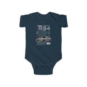 May include: Navy blue baby bodysuit featuring a graphic of a silver car with the text "R34" repeated vertically and horizontally. The text "RB26 DETT" and other text are also present. The bodysuit has short sleeves and a lap shoulder neckline.