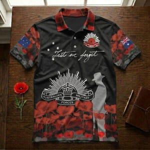 Könnte beinhalten: Schwarzes Poloshirt mit rotem und schwarzem Kragen und Ärmeln. Das Shirt hat ein Design mit roten Mohnblumen, dem Text "Lest we forget" und dem australischen Militäremblem. Die australische Flagge befindet sich auf den Ärmeln.