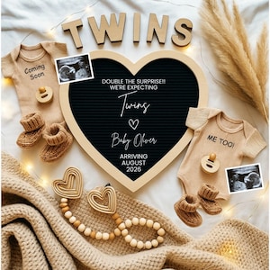 Puede incluir: Anuncio de embarazo de gemelos, con un tablero en forma de corazón que dice "Twins" y "Baby Oliver". La imagen incluye ropa de bebé, botines, chupetes y ecografías. La llegada está prevista para agosto de 2026.