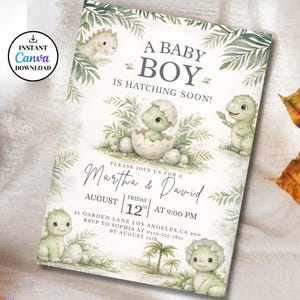 Puede incluir: Una invitación a un baby shower con un diseño de acuarela. La invitación presenta el texto "A Baby Boy Is Hatching Soon!" e incluye los nombres Martha & David, la fecha, la hora y el lugar. El diseño incluye ilustraciones de dinosaurios y follaje.