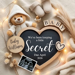 May include: A heart-shaped chalkboard with the words "We've been keeping a little Secret" and "Due April 2026". The image includes a teddy bear, baby booties, a pacifier, and a sonogram image, announcing a baby.