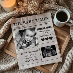 May include: A newspaper-style announcement titled "THE BABY TIMES" with a photo of a baby, sonogram, and text announcing a new baby and a big brother. A cup of coffee and a candle are in the background.