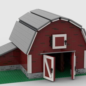 May include: A red brick barn model with a gray corrugated metal roof and white trim. The barn doors are open, revealing a green interior. The model sits on a green base, resembling a field.