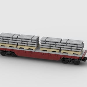 Puede incluir: Un vagón de tren rojo y gris que transporta pilas de objetos cilíndricos grises sobre palets de madera. El vagón tiene ruedas negras y está diseñado para el transporte de carga.