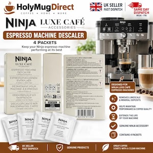 May include: A Ninja Luxe Café espresso machine descaler kit containing four packets. The packaging is white with black text, featuring the product name, usage instructions, and a barcode. It is displayed alongside a silver espresso machine.