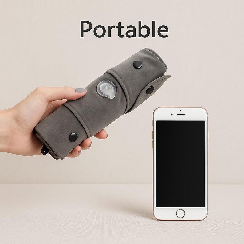 May include: A rolled-up gray portable item with black buttons and a white light, held next to a white smartphone. The word "Portable" is printed above the item.