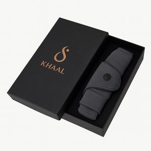 May include: A dark gray product is displayed inside a black box. The product is folded and secured with a black button. The box has the word "KHAAL" in gold lettering.