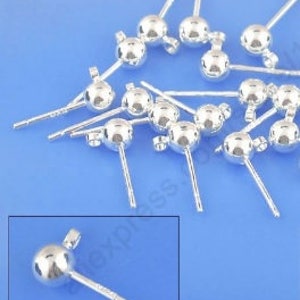 Peut inclure: Gros plan sur un groupe de tiges d'oreille en argent avec des boules rondes au sommet. Les tiges mesurent environ 2,5 cm de long et les boules ont un diam&egrave;tre d'environ 5 mm.
