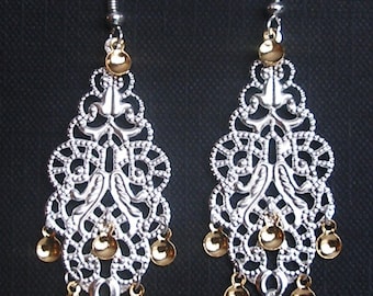 Peut inclure: Boucles d'oreilles en filigrane argent avec des accents dorés. Les boucles d'oreilles présentent un design délicat et complexe avec plusieurs niveaux de perles pendantes.