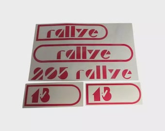 May include: A set of red and white rally stickers. The stickers include the word "rallye" in a stylized font, the number "205", and the number "13". The stickers are designed for automotive use.