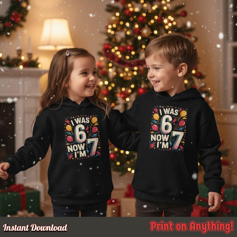 Happy boy and girl wearing matching black hoodies with the “I Was 6 Now I’m 7” design, standing near a Christmas tree with gifts. Shows family or sibling birthday celebration vibes.