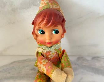 Muñeca Pixie Elf vintage de los años 60 con estampado floral psicodélico y cara de vinilo, ideal para colocar sobre estantes.