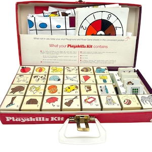 May include: Vintage Playskills Kit in a red case. The kit includes game cards with various illustrations, a spinner, and instruction cards. The case has a white handle and gold-colored clasps. The text "Playskills Kit" is printed on the case.