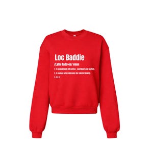 May include: A red crewneck sweatshirt with the text "Loc Baddie" in white, along with a definition. The definition includes the pronunciation, and the meaning of the word. The sweatshirt is a solid red color.