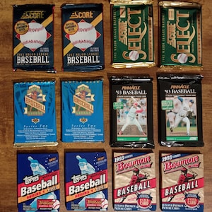 May include: A collection of vintage baseball card packs from various brands, including Score, Topps, and Bowman. The packs feature baseballs, player images, and text such as "1993 Major League Baseball" and "Series Two". The packs are in various colors, including blue, green, and red.