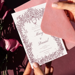 Elegant Victorian wedding invitation card with pink envelope and royal crest design