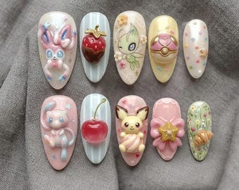 May include: A set of ten almond-shaped, decorated artificial nails. Each nail features a unique design, including cartoon characters, a chocolate-covered strawberry, a cherry, and floral accents. The nails are painted in pastel colors.