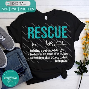 Op de afbeelding: Zwart T-shirt met het woord "RESCUE" in turquoise blokletters. Daaronder een pootafdruk, een hartslaglijn en een hartsymbool. Het shirt bevat ook een definitie van "rescue".