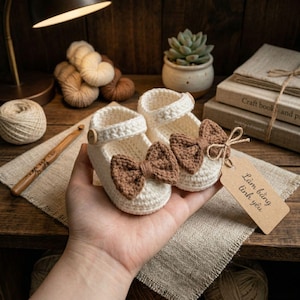 Beige handmade crochet booties with brown bows, soft knit baby shoes, ideal newborn baby gift and photo accessory.