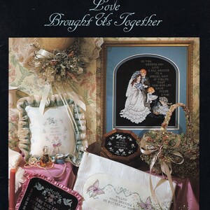 May include: A collection of cross-stitch embroidery designs featuring wedding themes. The designs include a couple with butterflies, a heart with the words "Our Hearts Are One Forever", and a couple with the text "May the Love You Share Today Grow Deeper and More Beautiful With Every Time".