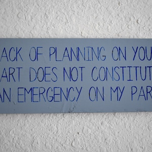 May include: A blue sign with white lettering that reads "Lack of planning on your part does not constitute an emergency on my part."