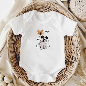 May include: A white short-sleeved baby bodysuit featuring a graphic print of a ghost wearing mouse ears, holding an orange pumpkin balloon with mouse ears, surrounded by small black bats and four-pointed star accents on the chest area.