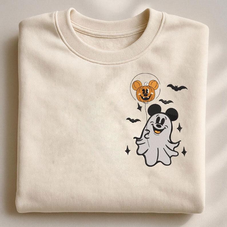May include: A cream-colored crewneck sweatshirt featuring an embroidered design on the chest. The embroidery depicts a white ghost wearing black mouse ears, holding a string attached to an orange pumpkin balloon with mouse ears, surrounded by bats.