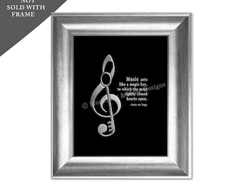 Peut inclure: Impression d'art mural noir et blanc avec une clé de sol argentée avec une clé à l'intérieur. La citation "La musique agit comme une clé magique, à laquelle les cœurs les plus étroitement fermés s'ouvrent." de Maria von Trapp est imprimée sous la clé de sol.
