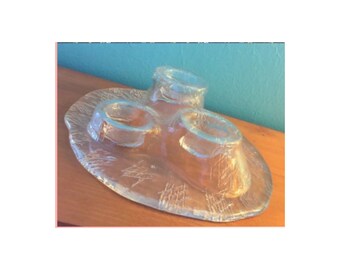 May include: A clear glass serving dish with three small bowls. The dish has a textured surface and the bowls are shaped like cones.