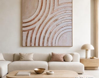 Könnte beinhalten: Ein großes quadratisches Wandbild mit einem strukturierten abstrakten Design aus konzentrischen Halbkreisen in Beige-, Creme- und Metallic-Kupfertönen. Das Kunstwerk ist in einem dünnen goldenen Rahmen gefasst und hat eine erhabene Oberfläche.