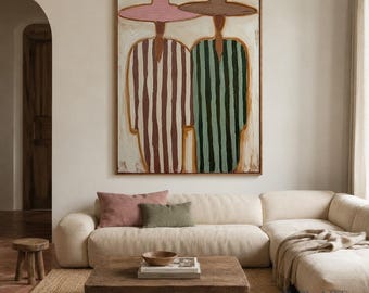 May include: A large rectangular wall painting featuring two stylized figures wearing wide-brimmed hats. The left figure wears a pink hat and a brown-striped garment, while the right figure wears a brown hat and a dark green-striped garment.