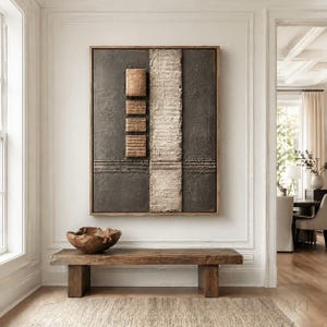 May include: A rectangular wall art piece featuring a dark charcoal textured background with a vertical cream-colored ribbed panel and four stacked square blocks in a warm tan shade, all enclosed within a simple wooden frame.