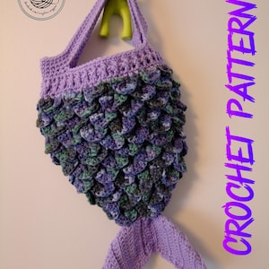 May include: Crochet mermaid tail bag pattern in PDF format. The bag is purple with green and blue scales. The bag has a purple crocheted handle.