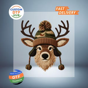 May include: A whimsical illustration of a deer wearing a camouflage and brown knit hat with a pom-pom and ear flaps. The deer has large antlers and a textured fur appearance. The image includes the text "Custom DTF Hub", "Fast Delivery", and "Ready to Press DTF Transfer".