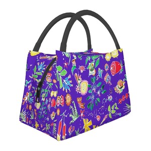 Puede incluir: Una bolsa de almuerzo morada con un colorido estampado floral. La bolsa tiene una cremallera negra y asas negras. El diseño incluye flores, hojas y otros elementos caprichosos en varios colores.