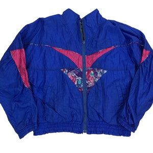 May include: A vintage blue windbreaker jacket with a full zipper closure. The jacket features pink and floral patterned accents on the chest and shoulders. The jacket has a stand-up collar and elastic cuffs and hem.