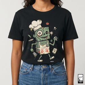 Może przedstawiać: Czarny t-shirt z kresk&oacute;wkowym wzorem szefa kuchni zombie. Zombie ma na sobie czapkę kucharską i fartuch z napisem "FRESH" i odciskami dłoni. Pomidor i pudełko "BRAINS" są r&oacute;wnież widoczne w projekcie.