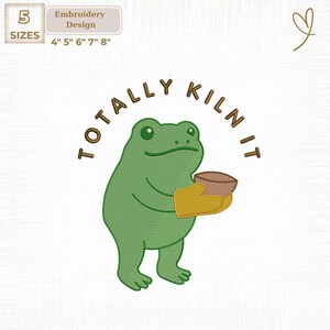 May include: An embroidery design featuring a green frog holding a brown bowl in a yellow oven mitt. The text "TOTALLY KILN IT" is in a brown arc above the frog. The design is available in 5 sizes, from 4" to 8".
