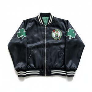 May include: Black satin bomber jacket with a green and white striped collar, cuffs, and hem. Features a Boston Celtics logo patch on the chest and shamrock patches on the sleeves. The jacket has a full-length zipper.