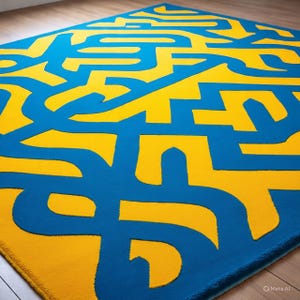 Puede incluir: Una alfombra rectangular con un diseño abstracto y audaz. La alfombra presenta una vibrante combinación de azul y amarillo, con el amarillo formando un patrón laberíntico sobre el fondo azul. La alfombra está hecha de un material suave.