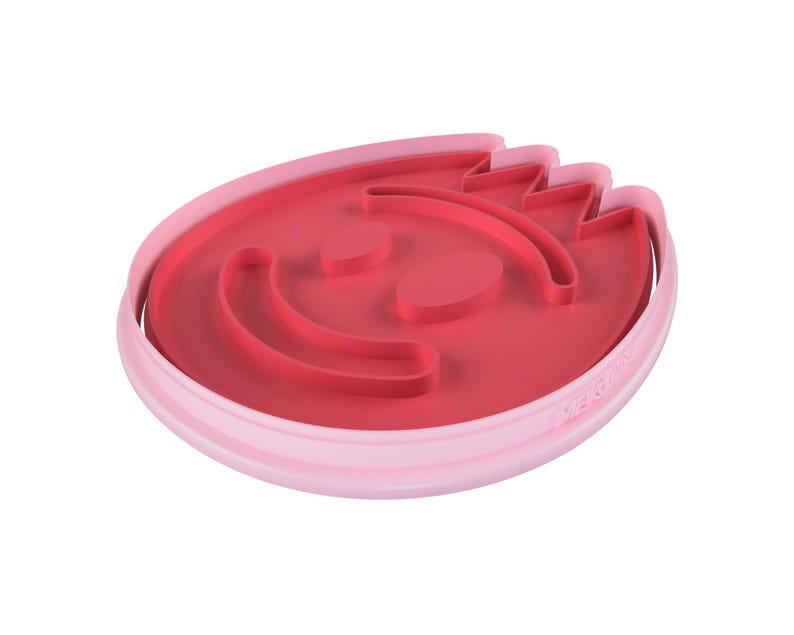 May include: A two-tone pink cookie cutter in the shape of a smiling face. The inner portion is a darker shade of pink, with the facial features raised. The outer rim is a lighter pink.
