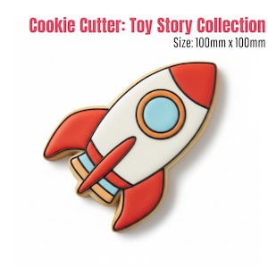 Può includere: Un tagliabiscotti a forma di razzo della collezione Toy Story. Il tagliabiscotti è bianco con dettagli rossi, un oblò blu e un contorno beige. Il testo "Cookie Cutter: Toy Story Collection" e "Size: 100mm x 100mm" sono visibili.