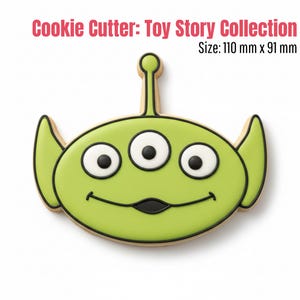 Peut inclure: Emporte-pièce vert en forme d'extraterrestre à trois yeux de la collection Toy Story. Le découpoir a des contours noirs et des yeux blancs et noirs. Le texte "Cookie Cutter: Toy Story Collection" et "Size: 110 mm x 91 mm" est dans l'image.
