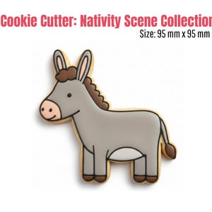 May include: A donkey-shaped cookie cutter from the Nativity Scene Collection. The cookie cutter is gray with brown accents and a beige outline. The text "Cookie Cutter: Nativity Scene Collection" and "Size: 95 mm x 95 mm" are in the image.