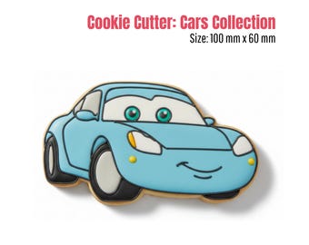 May include: A light blue car-shaped cookie cutter from the Cars Collection. The cookie cutter has black tires, white headlights, and a smiling face. The text "Cookie Cutter: Cars Collection" is at the top. The size is 100 mm x 60 mm.